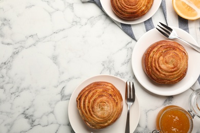 Photo of Flat lay composition with buns and space for text on white marble background. Fresh from oven