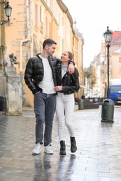 Lovely young couple walking together on city street. Romantic date