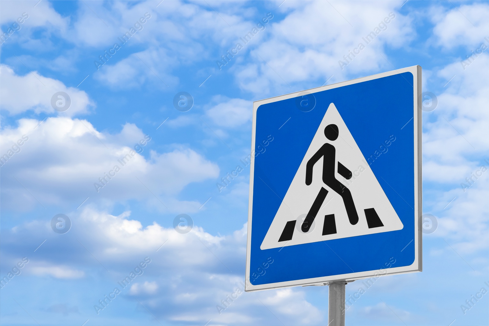 Photo of Post with Pedestrian Crossing traffic sign against blue sky on sunny day. Space for text