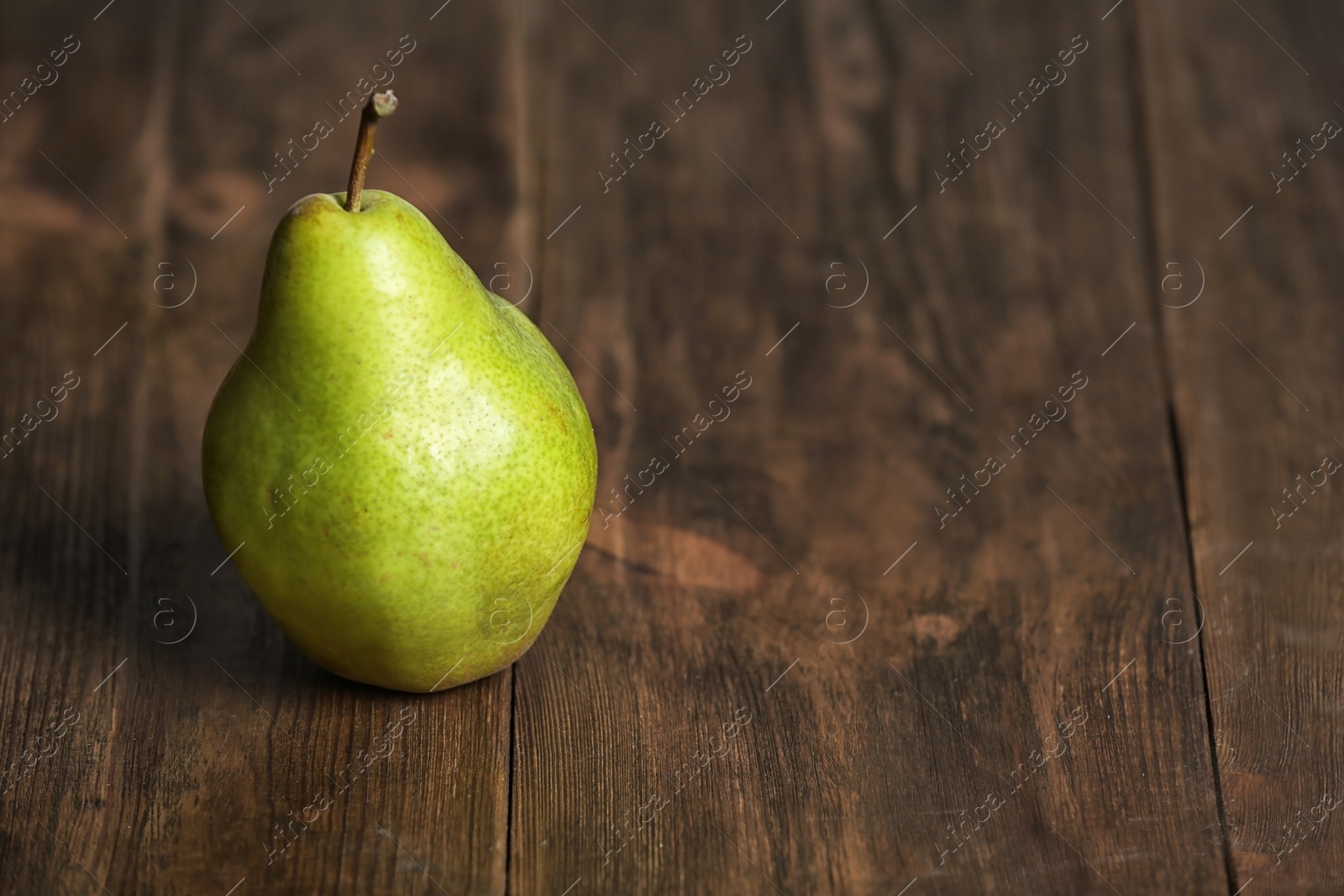 Photo of Ripe pear on wooden background. Space for text