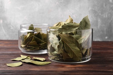 Photo of Bay leaves in glass jars on wooden table