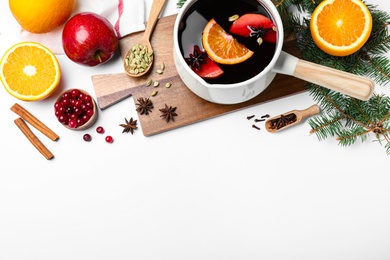 Photo of Delicious mulled wine and ingredients on white table, flat lay. Space for text