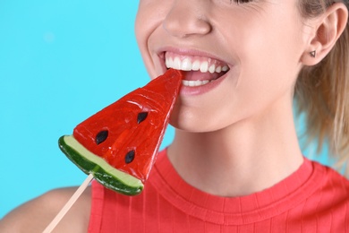 Photo of Young pretty woman with candy on colorful background, closeup