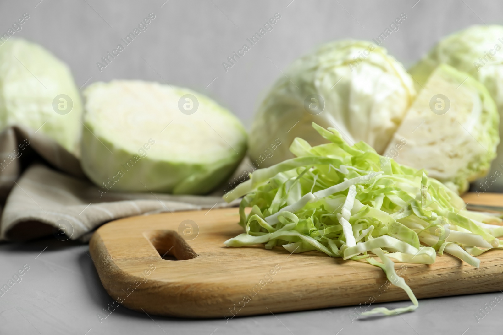 Photo of Fresh shredded cabbage on grey table, closeup