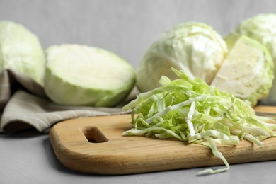 Photo of Fresh shredded cabbage on grey table, closeup