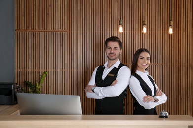 Photo of Smiling receptionists at desk in modern lobby