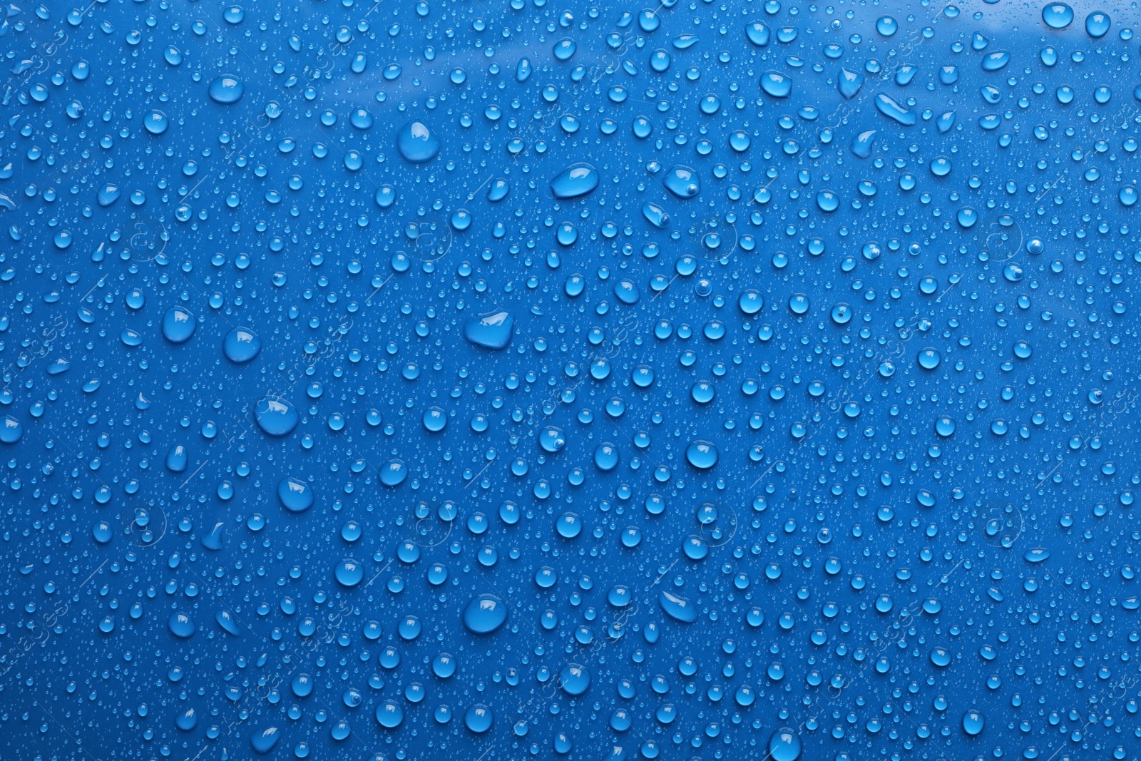 Photo of Water drops on blue background, top view