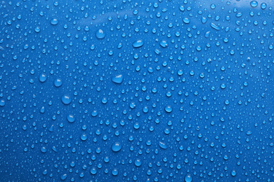 Water drops on blue background, top view