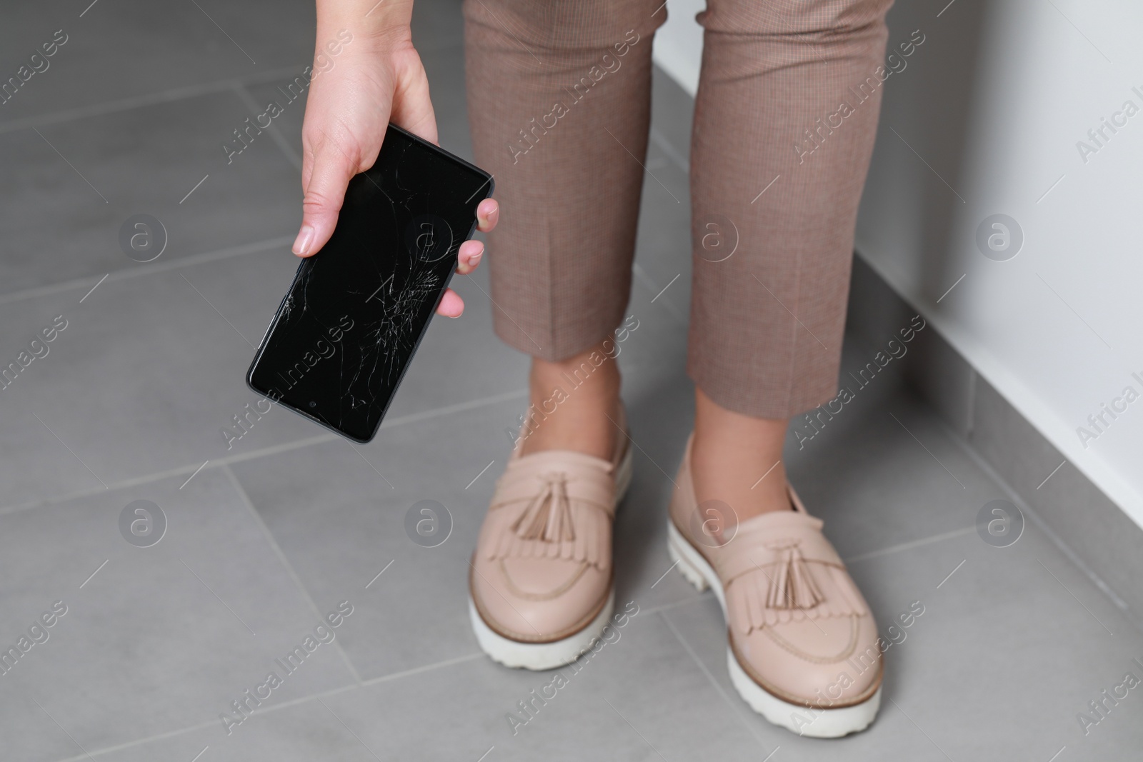 Photo of Woman with damaged smartphone indoors, closeup. Device repairing