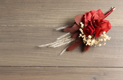 Photo of Beautiful boutonniere on wooden background, top view. Space for text