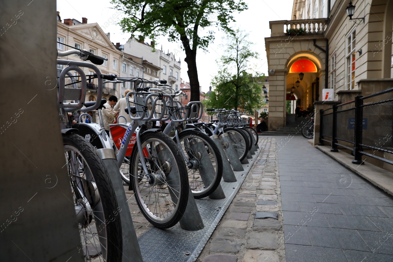 Photo of LVIV, UKRAINE - APRIL 27, 2019: Parking with bicycles for rent on Market Square near Town Hall