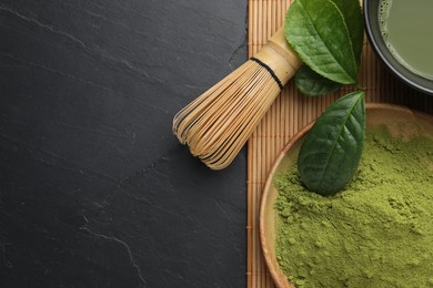 Photo of Green matcha powder, bamboo whisk and leaves on black table, flat lay. Space for text