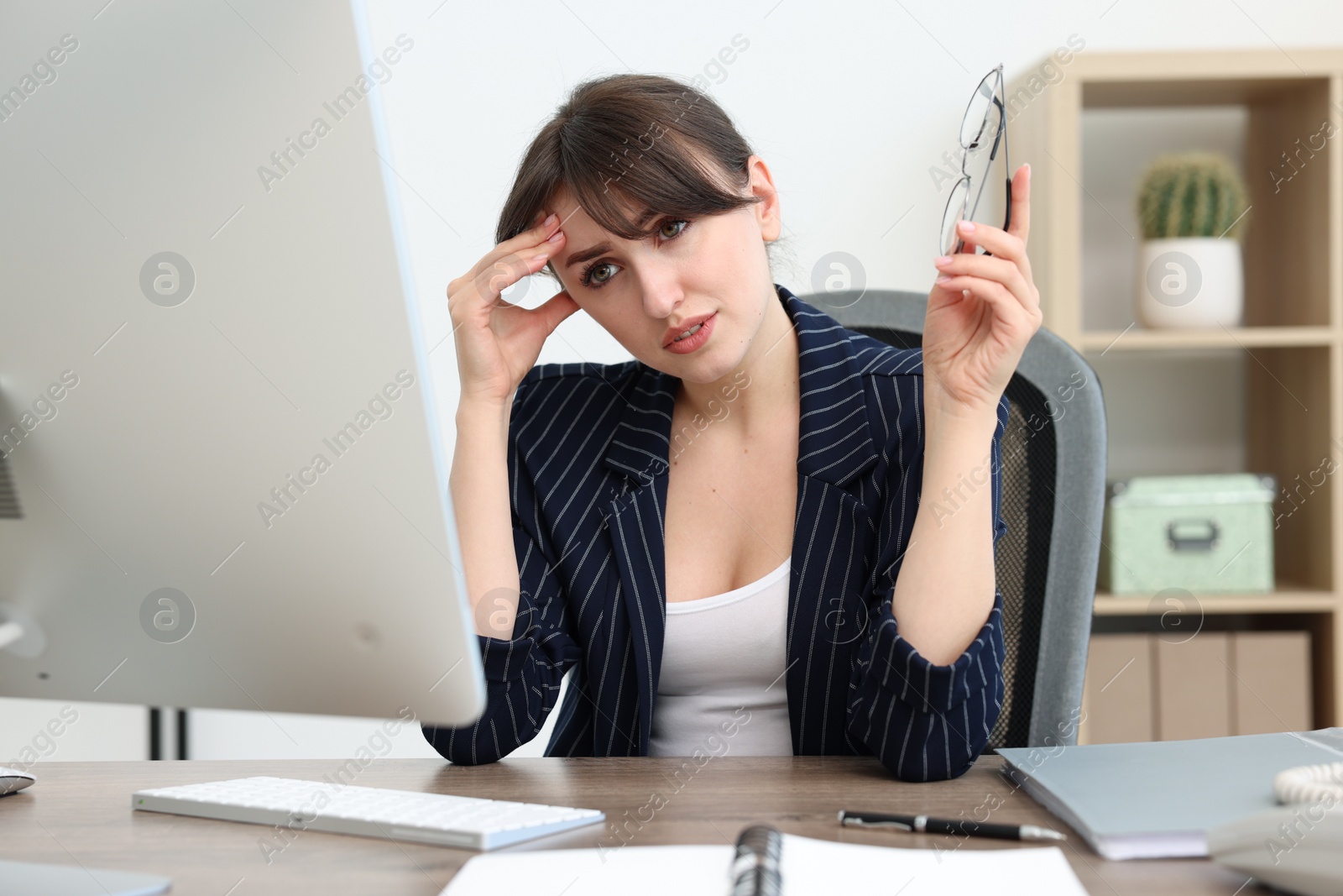 Photo of Overwhelmed office worker sitting at table with computer indoors