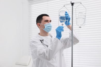 Photo of Doctor setting up IV drip in hospital