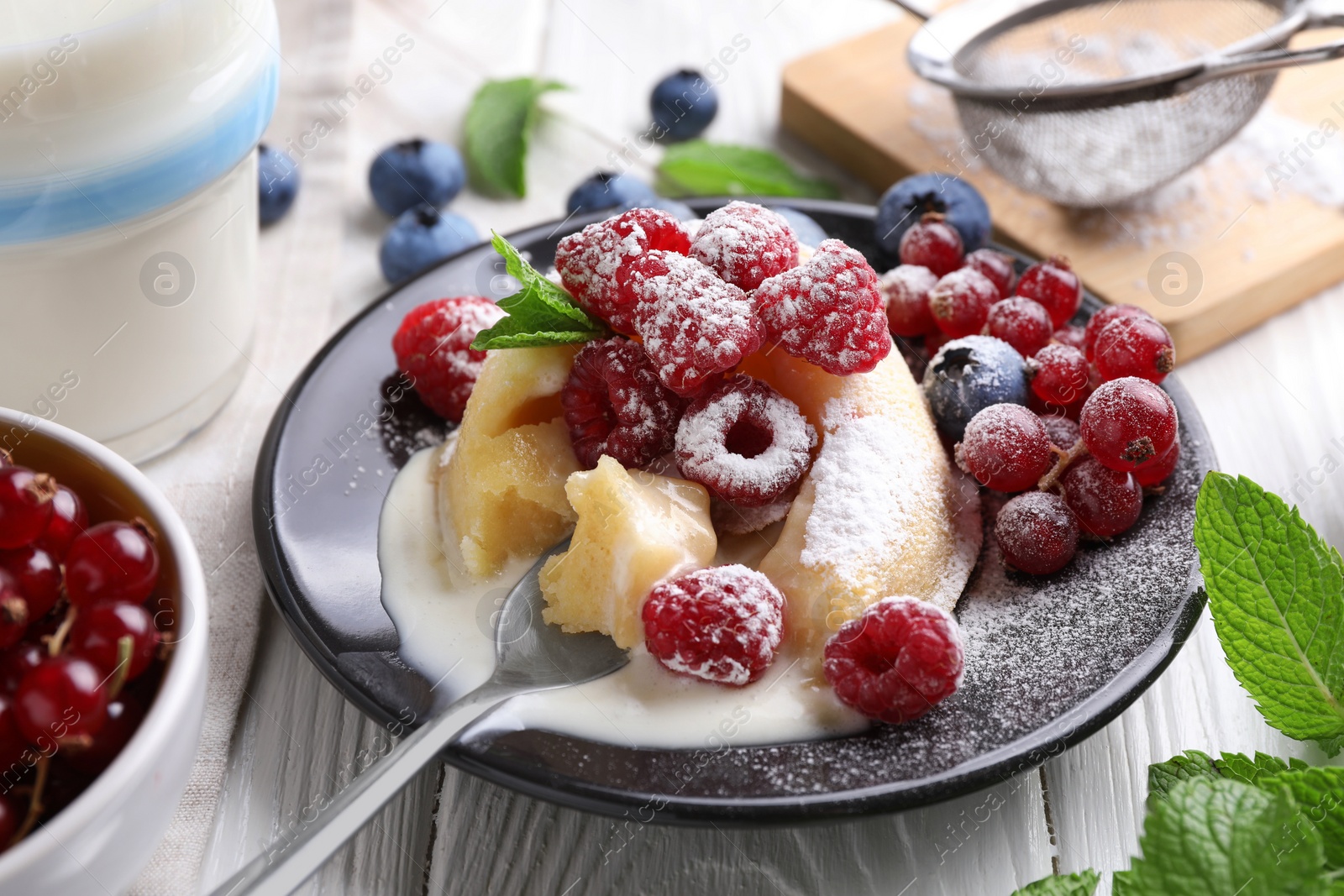 Photo of Delicious vanilla fondant served with fresh berries on white wooden table, closeup