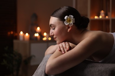 Photo of Spa therapy. Beautiful young woman lying on massage table in salon, space for text