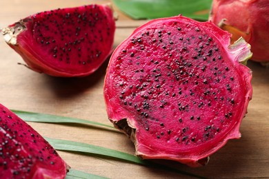 Delicious cut red pitahaya fruit on wooden board, closeup