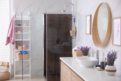 Photo of Bathroom interior with shower stall, counter and shelving unit. Idea for design