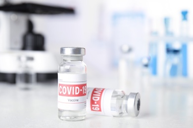 Photo of Vials with vaccine against Covid-19 on white table indoors