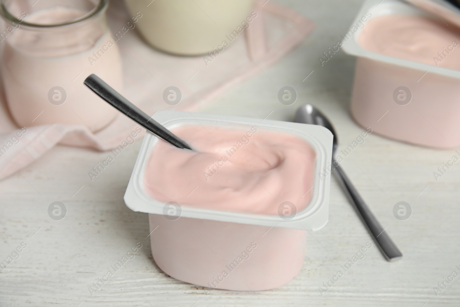 Photo of Tasty organic yogurt on white wooden table