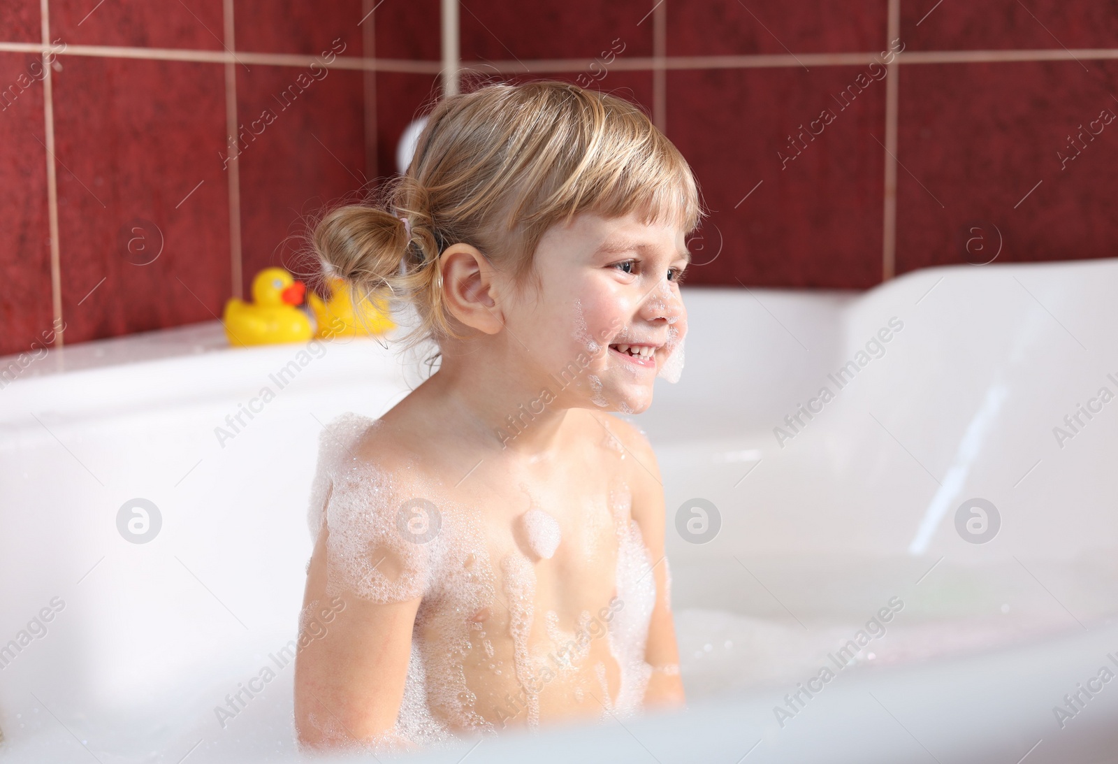 Photo of Happy girl bathing in tub at home