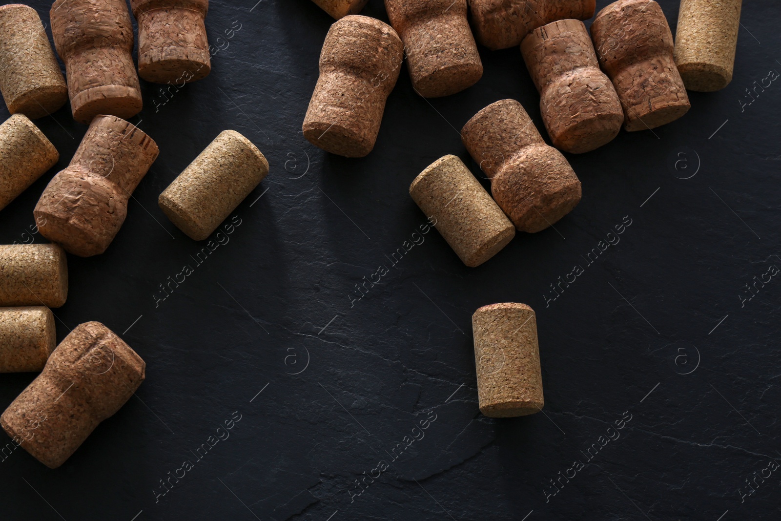 Photo of Wine bottle corks on black table, flat lay