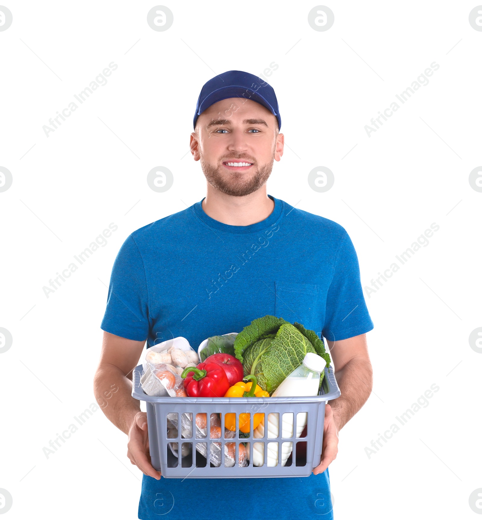 Photo of Delivery man holding plastic crate with food products on white background