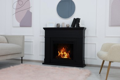 Photo of Black stylish fireplace with accessories under round mirror in cosy living room