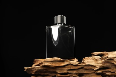 Luxury men`s perfume in bottle against black background, low angle view