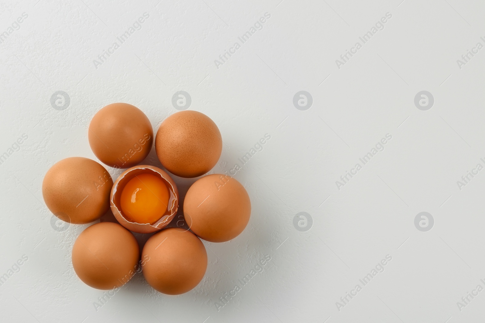 Photo of Raw chicken eggs on white table, flat lay. Space for text