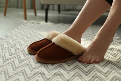 Photo of Woman in soft slippers at home, closeup