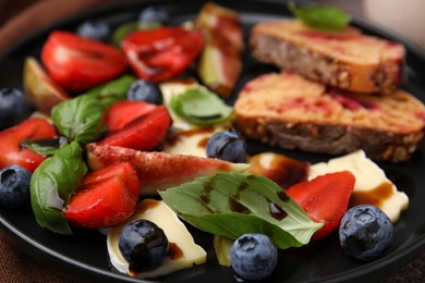 Delicious salad with brie cheese, berries and balsamic vinegar on plate, closeup