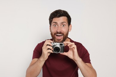 Man with camera on white background. Interesting hobby