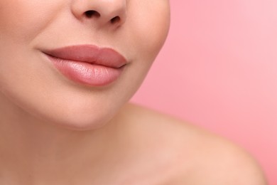 Photo of Woman with beautiful lips on pink background, closeup. Space for text