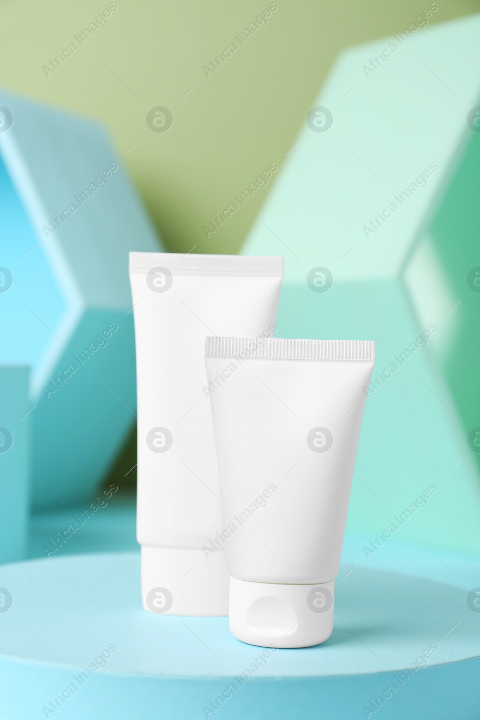 Photo of Composition with tubes of hand cream on light blue table