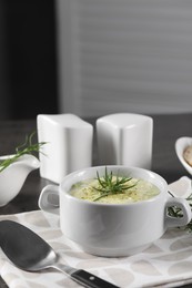 Photo of Delicious cream soup with tarragon, spices and potato in bowl served on dark textured table. Space for text
