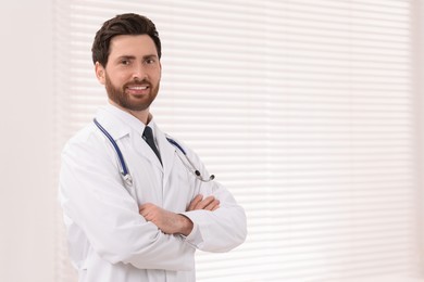 Medical consultant with stethoscope in clinic, space for text