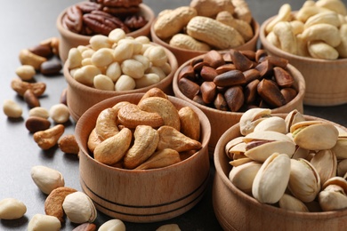 Photo of Bowls with organic nuts on table. Snack mix