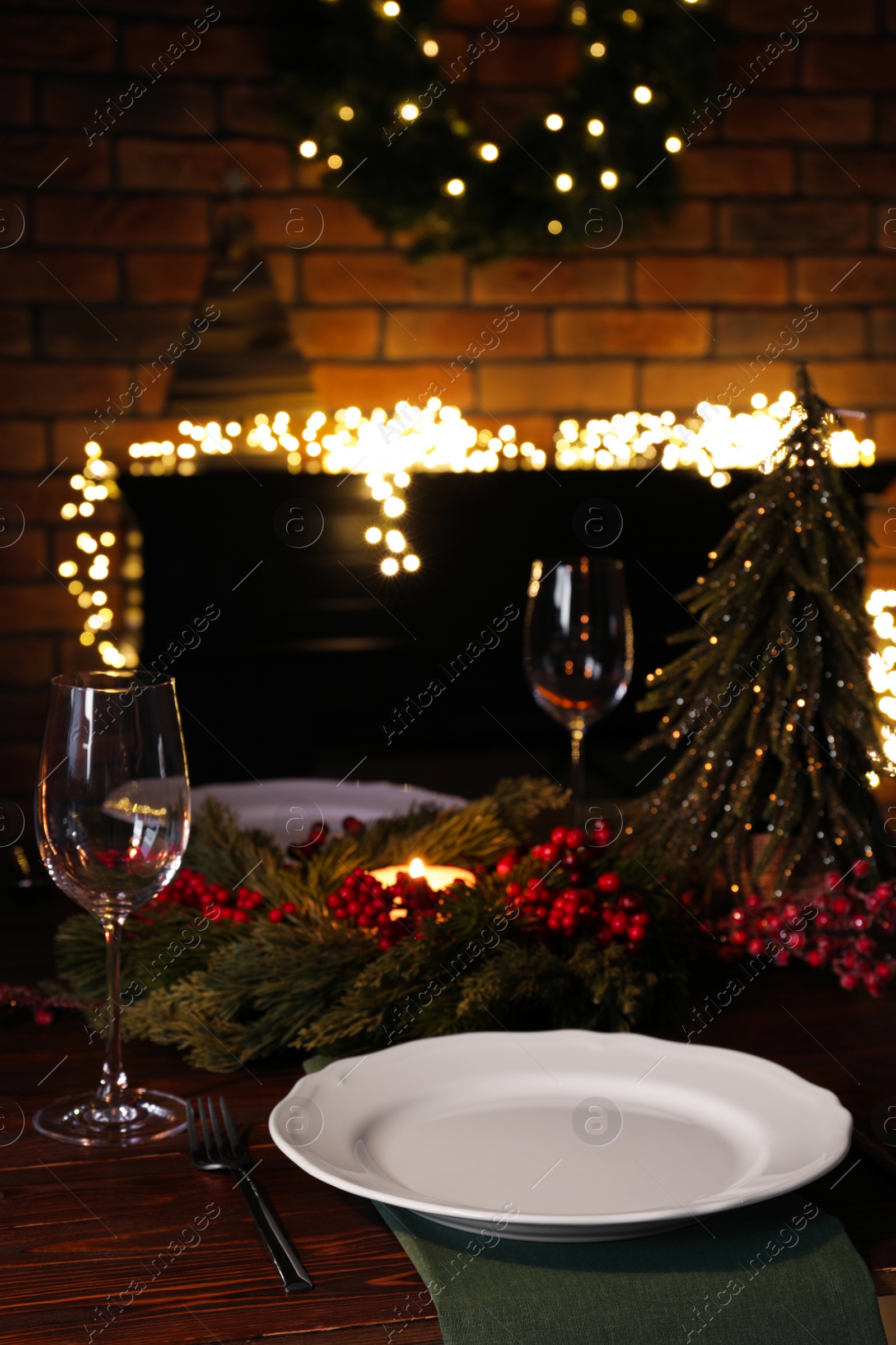 Photo of Plates, glasses and festive decor on wooden table