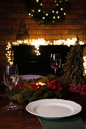 Plates, glasses and festive decor on wooden table