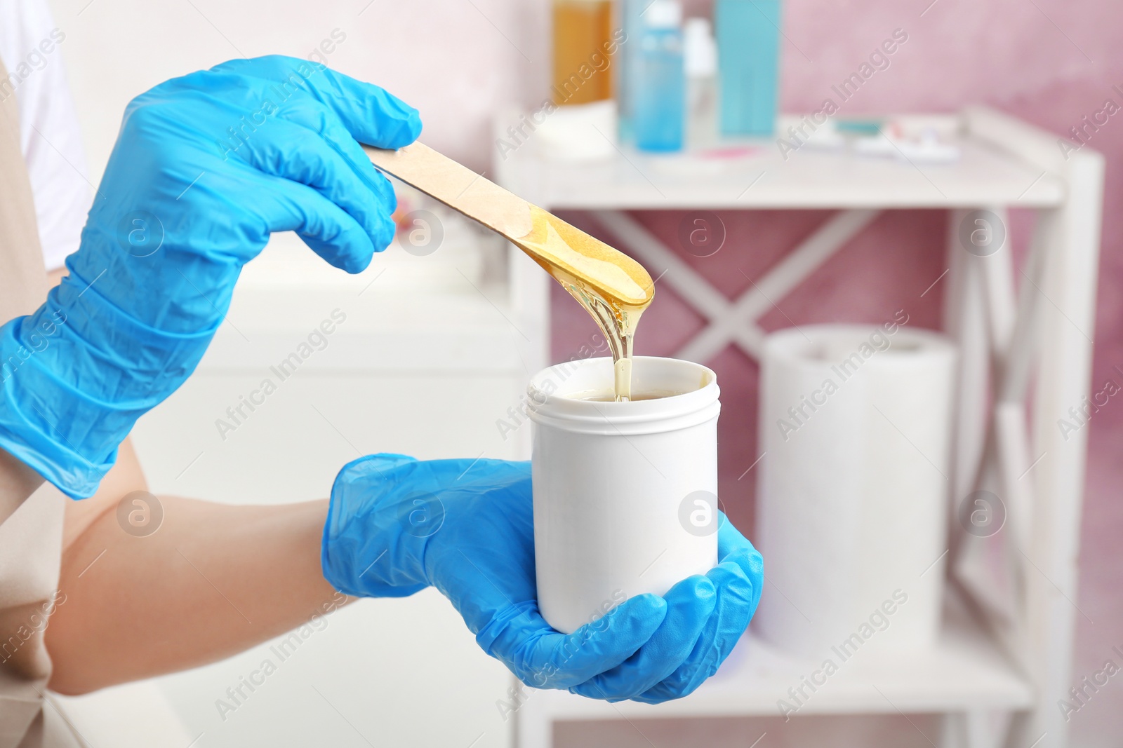 Photo of Woman with wooden stick and sugaring paste indoors, closeup