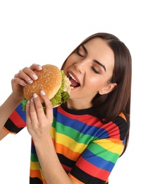 Photo of Young woman eating tasty burger on white background