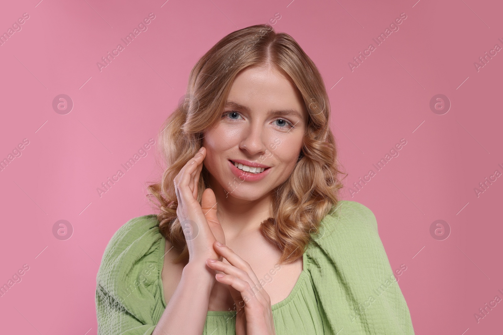 Photo of Portrait of beautiful woman with blonde hair on pink background