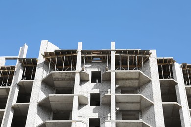 Photo of Construction site with unfinished building on sunny day, low angle view