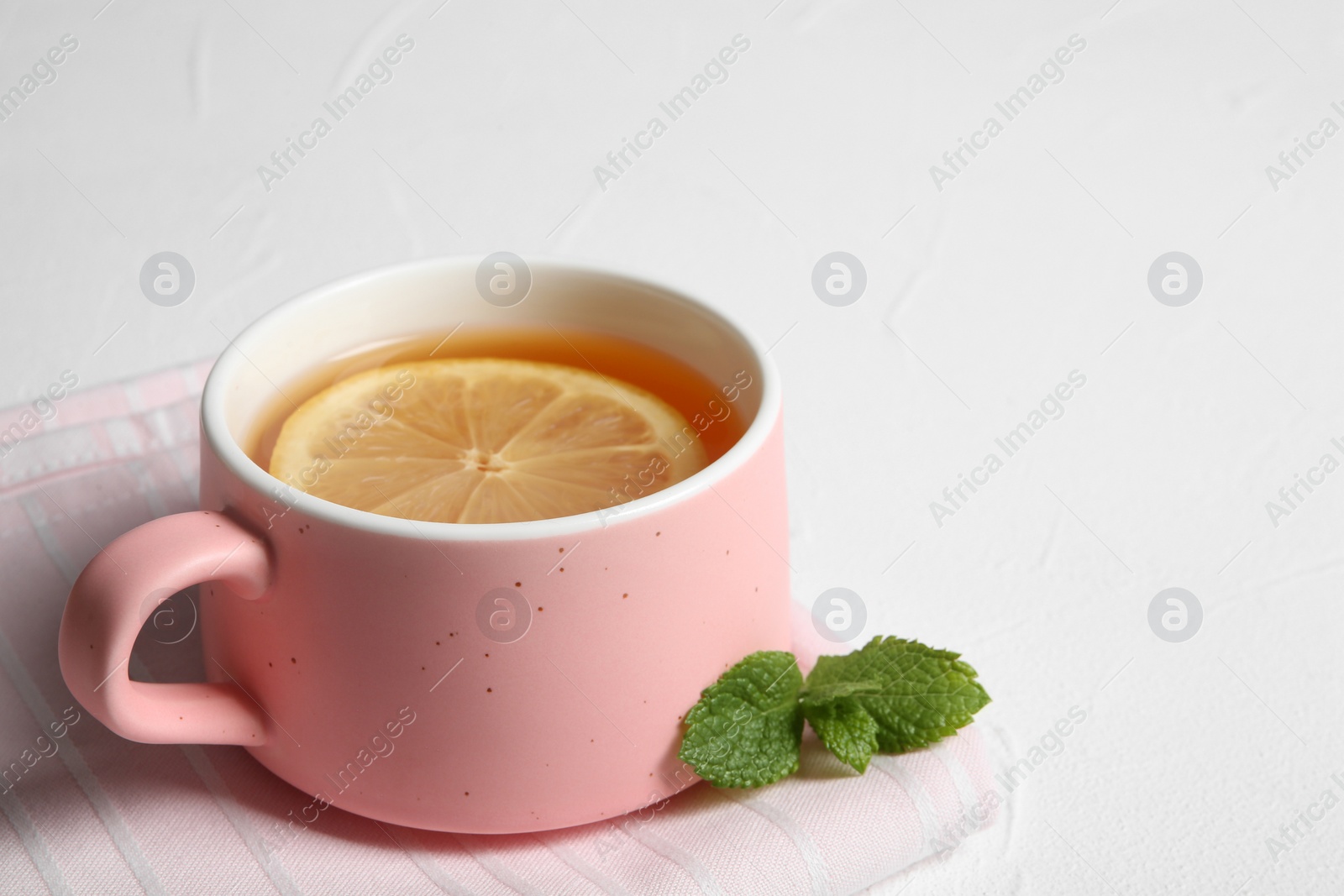 Photo of Cup with hot tea and lemon on white background. Space for text