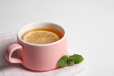 Cup with hot tea and lemon on white background. Space for text