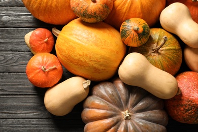 Photo of Flat lay composition with different pumpkins on wooden background. Autumn holidays