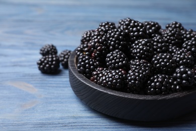 Photo of Fresh ripe blackberries on blue wooden table, closeup