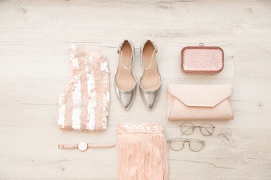 Flat lay composition with stylish outfit for woman on wooden background