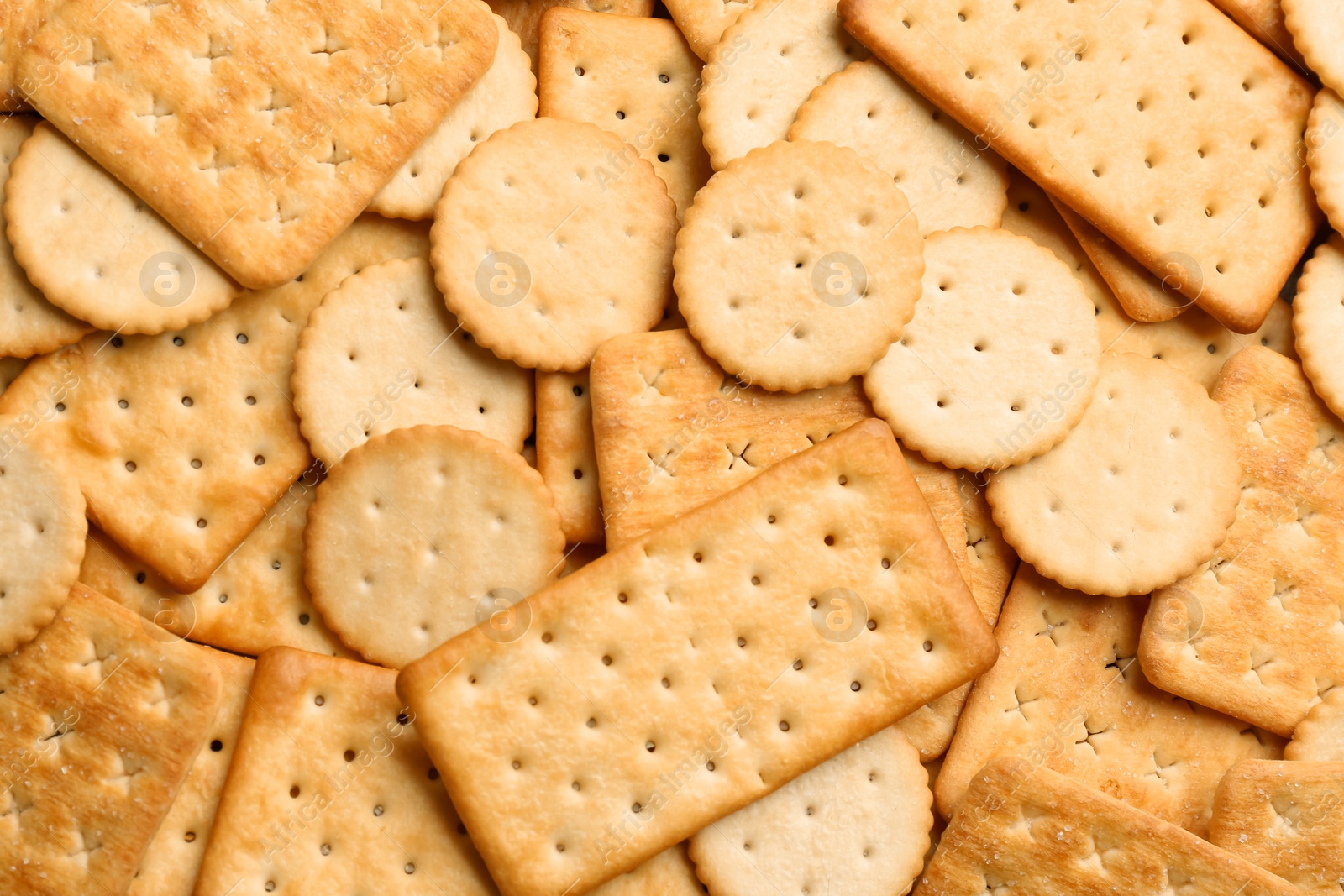 Photo of Many delicious crackers as background, top view